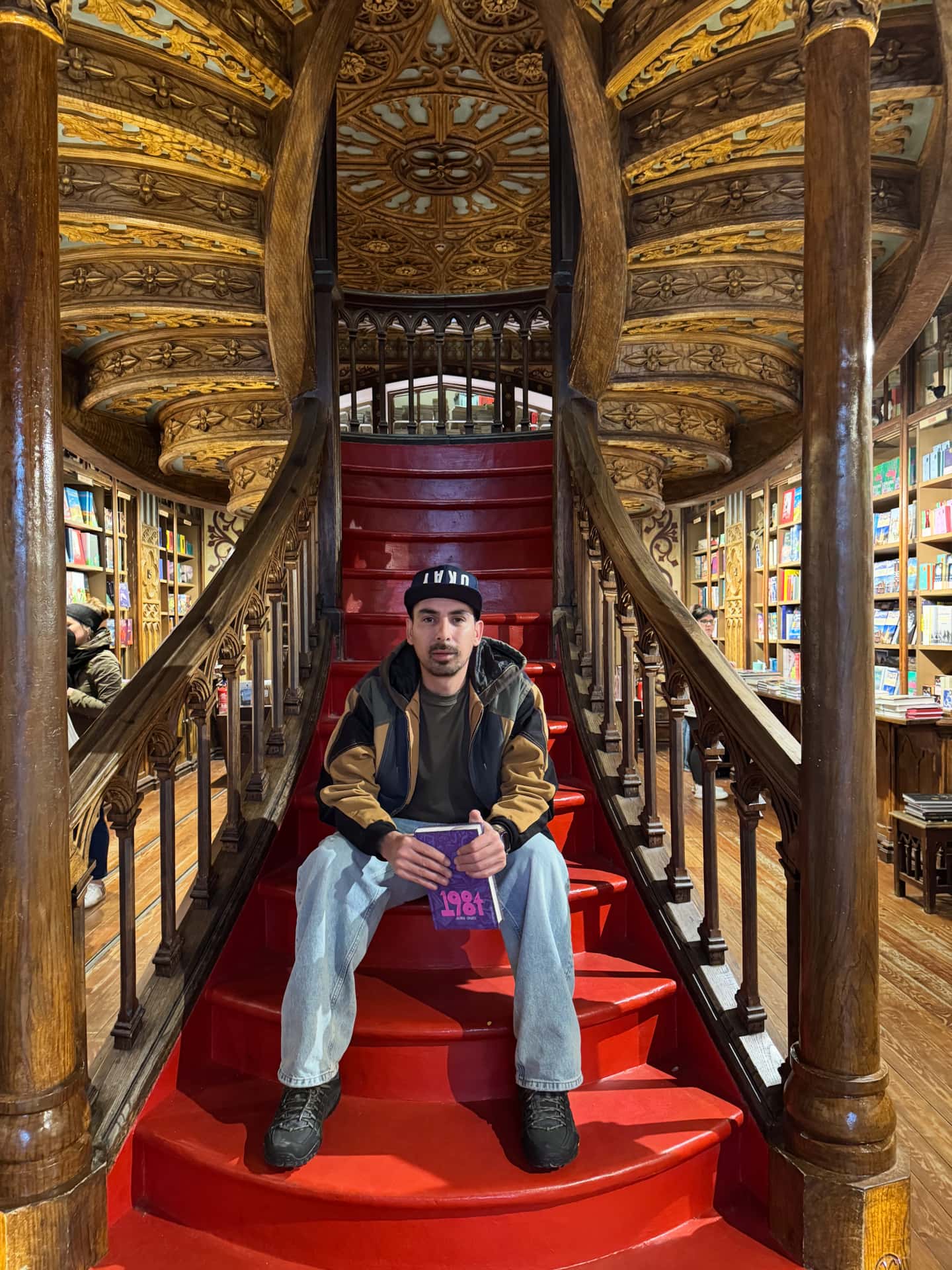 Pedro posing with his new book, in the iconic staircase of a world famous library in Porto.