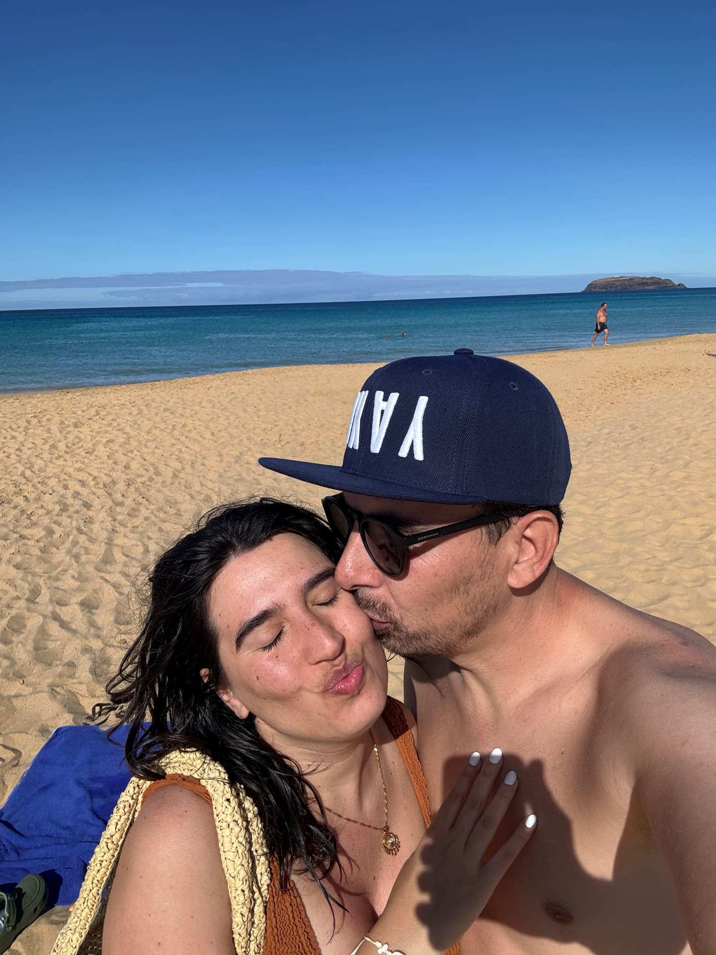 Pedro and Nina taking a selfie with an empty Porto Santo beach as the background.
